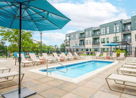 A lounge pool surrounded by several lounge chairs and umbrellas for shade.