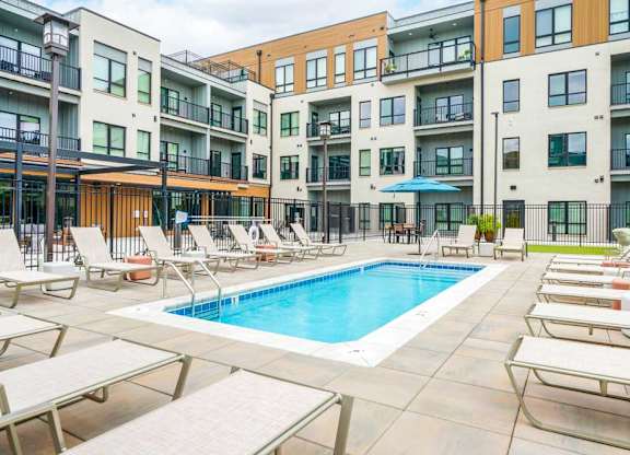 A lounge pool surrounded by several lounge chairs and umbrellas for shade.