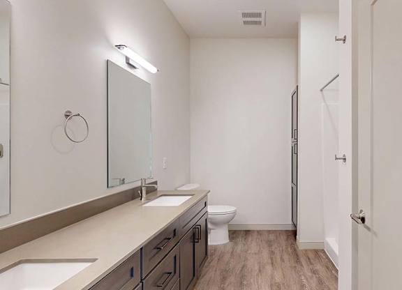 A bathroom with a toilet, sink, and mirror.