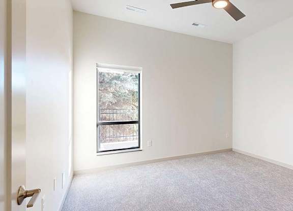 A room with a window and a ceiling fan.