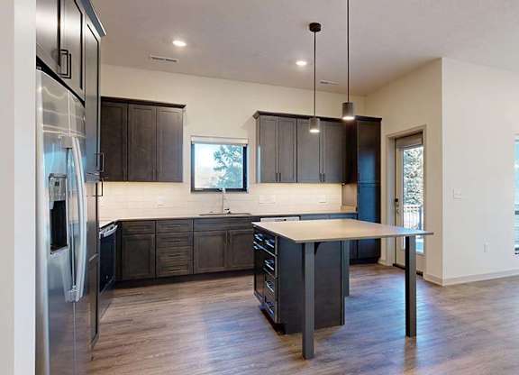 A modern kitchen with dark wood cabinets and a central island.