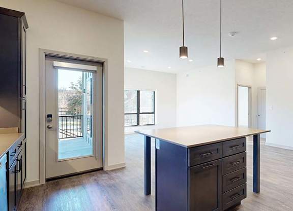 A kitchen with a large island and a view of a backyard.