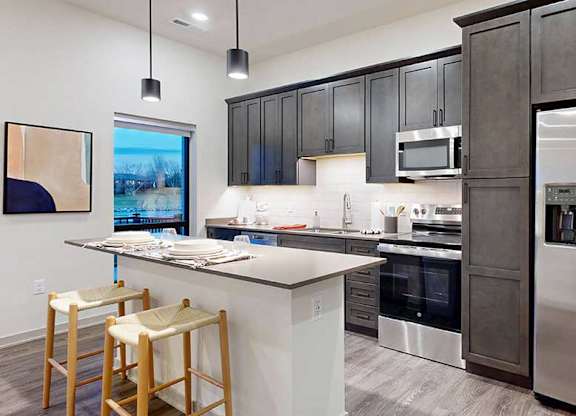 a kitchen with a full-size refrigerator, range, and microwave