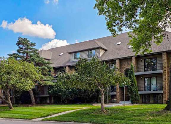 An apartment building with mature trees in front of it