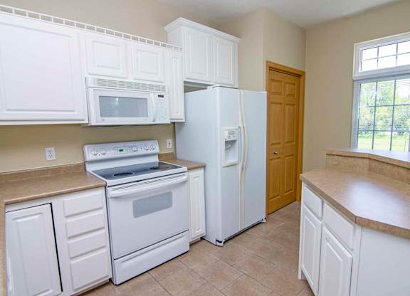 a kitchen with white appliances and white cabinets