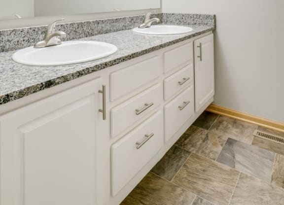 bathroom with dual sinks and white cabinetry at Cascade Pines Duplex and townhomes