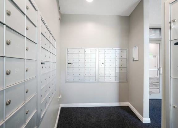 a row of mailboxes in a room next to the door to the main lobby