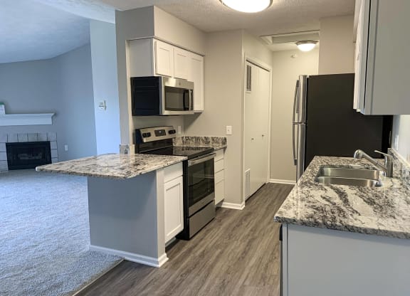 Renovated kitchen with white cabinets and stainless steel appliances at Eagle Run Apartments in Omaha Nebraska