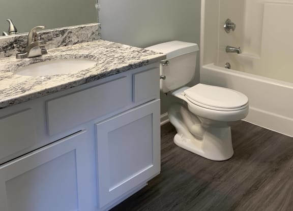 Bathroom with white vanity for storage and large mirror with great lighting at Eagle Run Apartments in Omaha Nebraska
