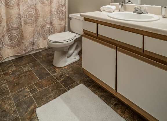 A bathroom with a toilet, sink, and shower curtain.