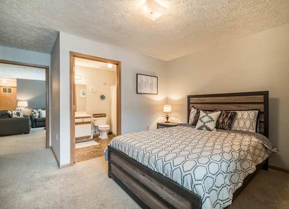 A bedroom with a large bed and attached bathroom