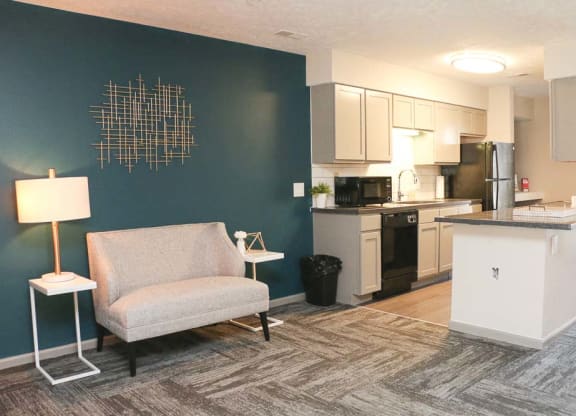 View of sitting chair and kitchen in the clubhouse-Eagle Run Apartments in Omaha NE