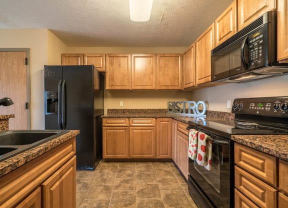 a kitchen with black appliances and wooden cabinets