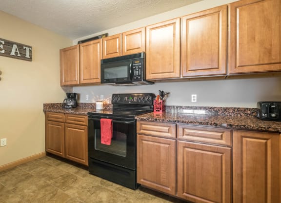 a kitchen with black appliances and wooden cabinets