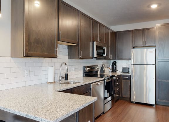 a kitchen with dark wood cabinets and white granite countertops