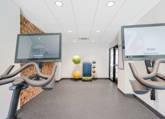 a room with chairs and monitors and a gym ball