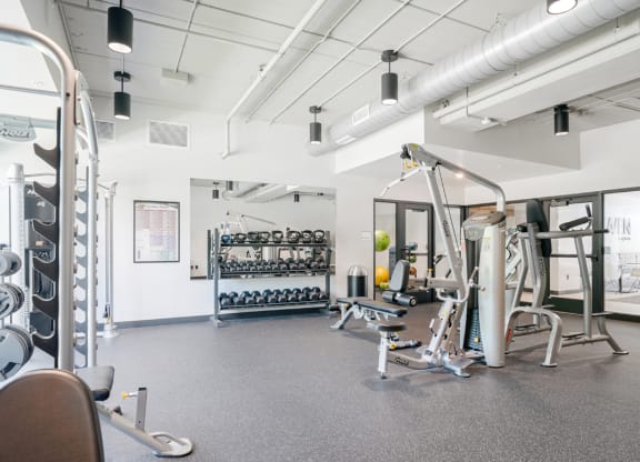 a gym with weights and other exercise equipment in a building with white walls