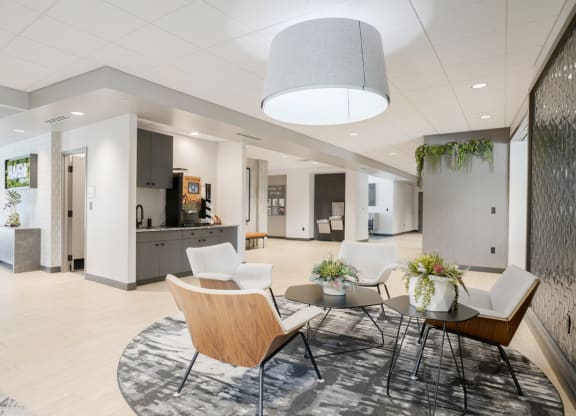 a main lobby area with chairs and a table and coffee bar