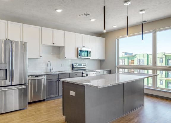 Large windows filter abundant natural light into the spacious kitchen in the Melody floor plan at Haven at Uptown in Lincoln, NE