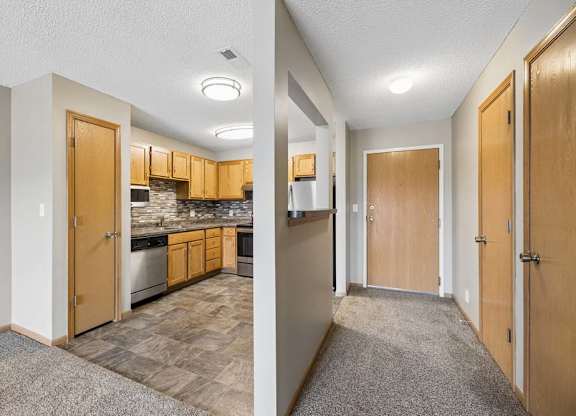 A kitchen and hallway are shown in this image.