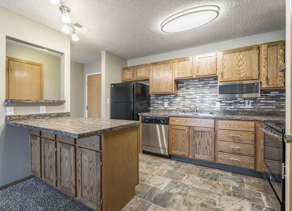 a renovated kitchen with tile backsplash and new appliances