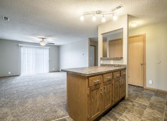 an open living room and kitchen with a door to a bedroom