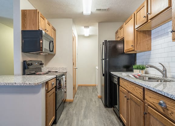 Kitchen with hardwood-style flooring and subway tile backsplash at Williamsburg Park Apartments in Lincoln NE