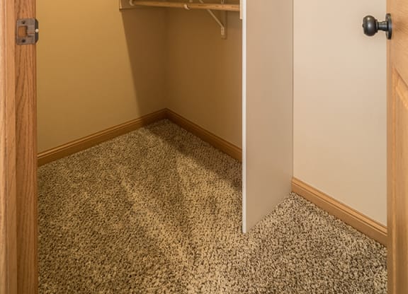 a large walk-in closet with lots of built-in storage space and shelving at Grand Legacy Apartments