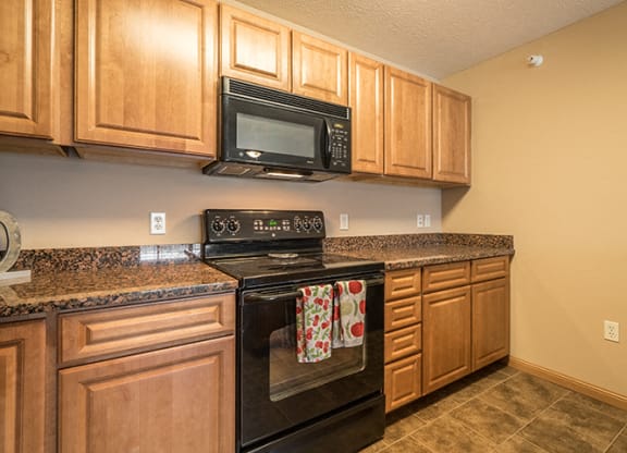 a kitchen with black appliances and wooden cabinets