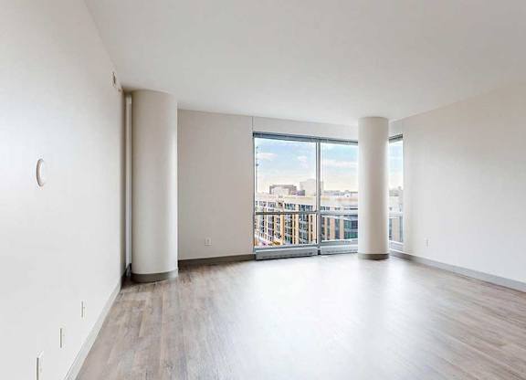 a spacious bright living area with large windows and wood-style flooring