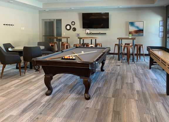 a games room with a pool table and a tv