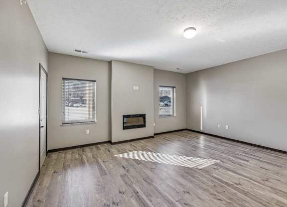 A spacious room with a wood floor and a window.