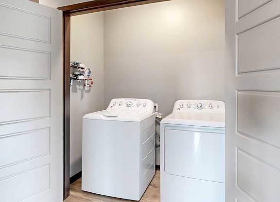 A full sized washer and dryer in a double door closet.