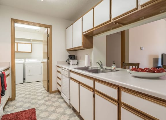 a kitchen with white cabinets and a sink      and a door