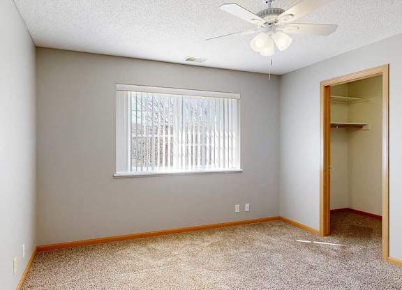bedroom with a ceiling fan and a window with blinds