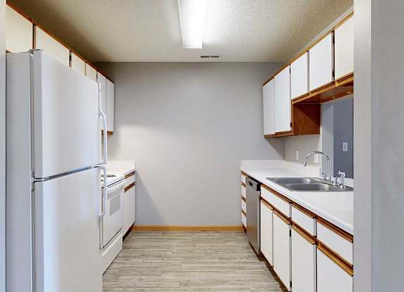 galley-style kitchen with a white appliances and white cabinets.