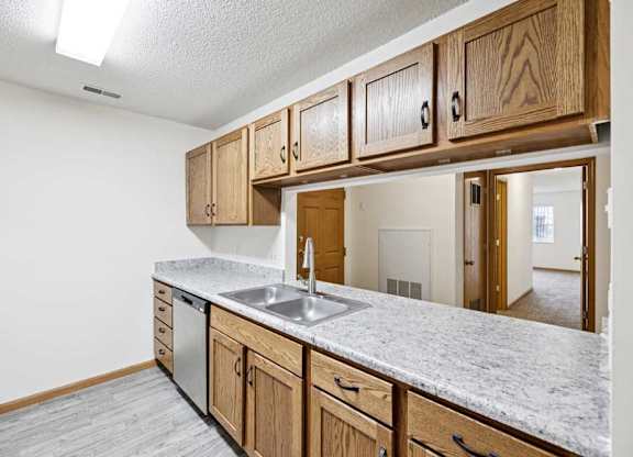 A kitchen with wooden cabinets and a marble countertop.