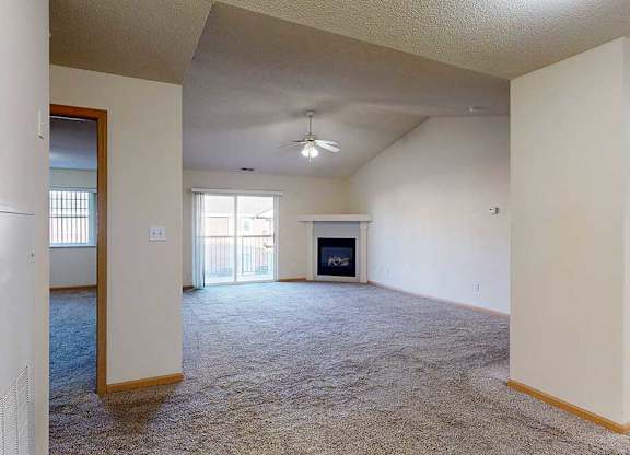 spacious living room with a fireplace and a ceiling fan