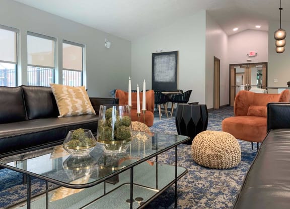 a clubhouse community room with couches and a glass table