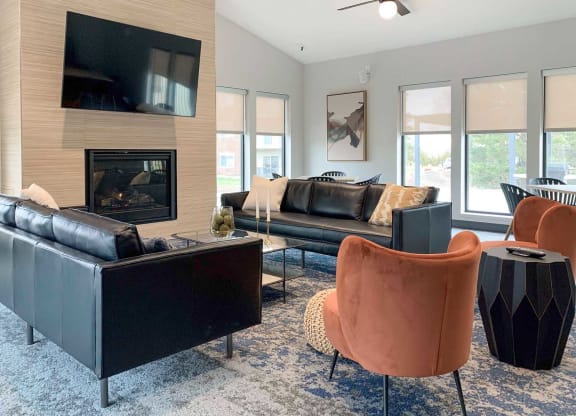 a clubhouse living room with leather furniture and a fireplace