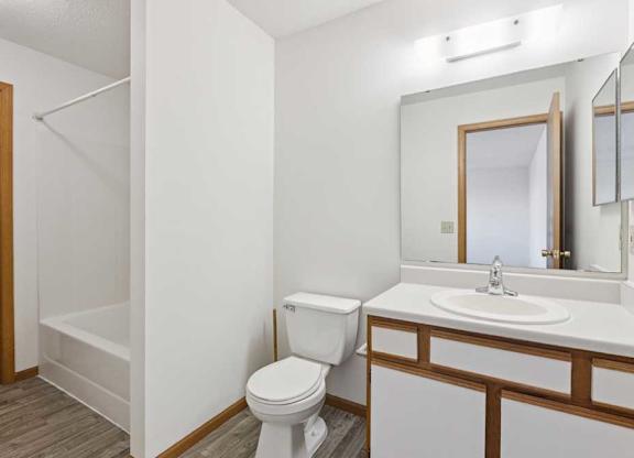 A white toilet sits next to a sink in a small bathroom.