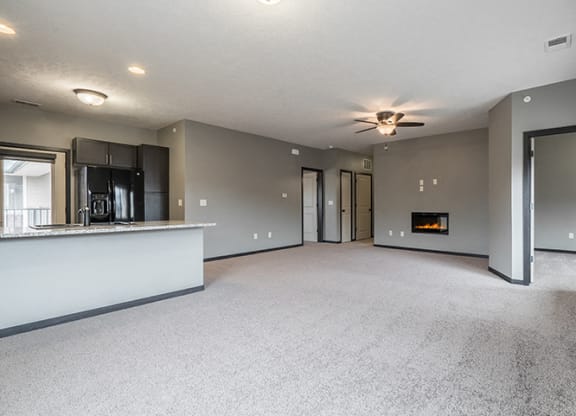 Interiors-Living room with electric fireplace and ceiling fan at The Villas of Omaha at Butler Ridge in Omaha Nebraska