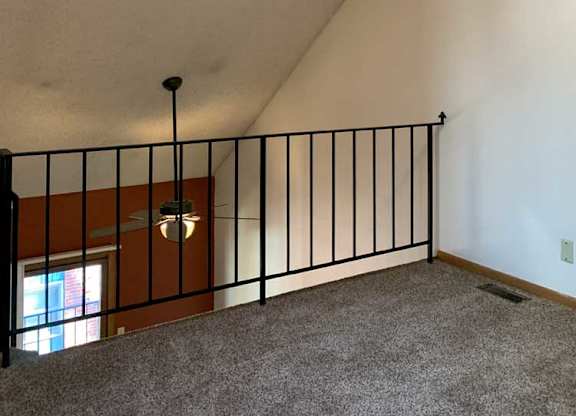 a loft area with a skylight and a metal railing