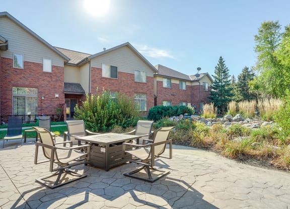 a courtyard patio with a fire pit and chairs