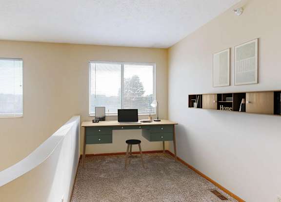 A room with a desk and a chair in it.