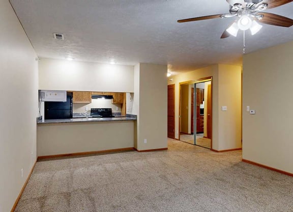 an open living room and dining area next to a kitchen breakfast bar
