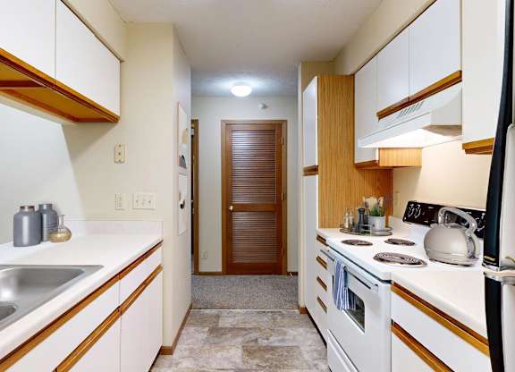A kitchen with white cabinets and a wooden accent.
