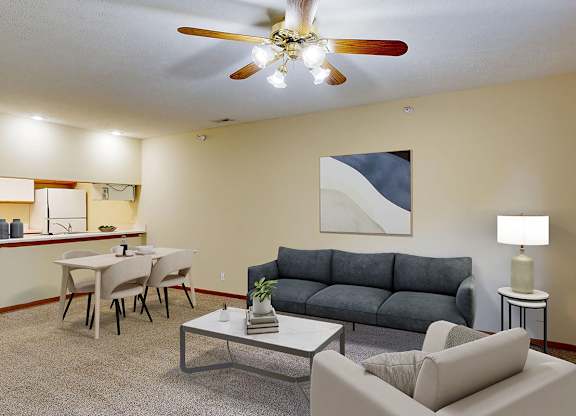 A living room with a navy couch, a coffee table, and a ceiling fan.