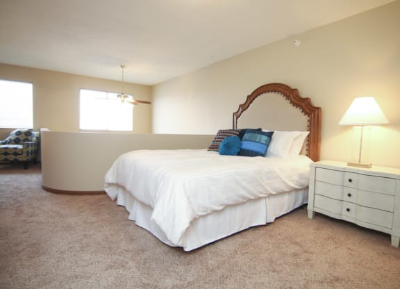 Lofted bedroom with two windows and area over looking living room below