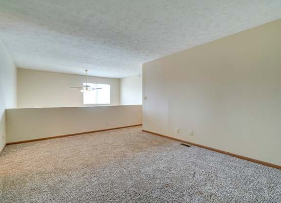A room with a carpeted floor and a window.